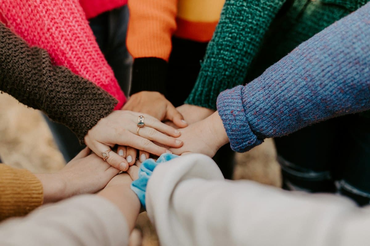 Hands stacked together in a circle of shared purpose